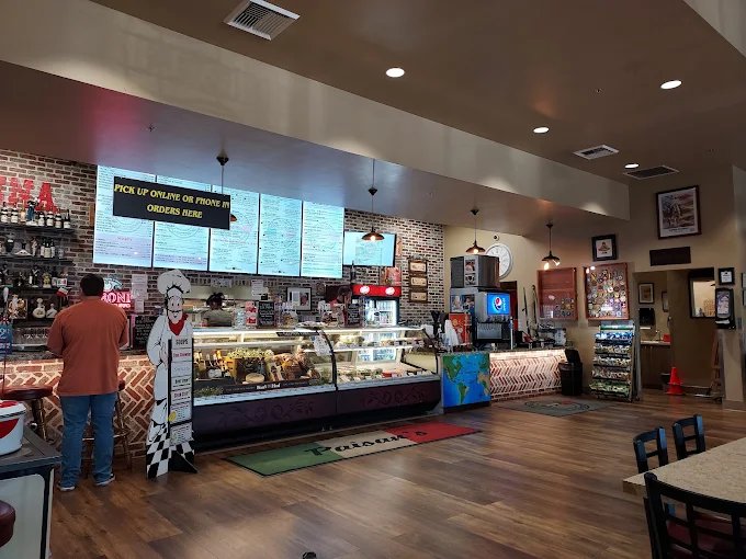 Inside Paisan&rsquo;s deli: the ordering counter, menu boards, and deli cases
