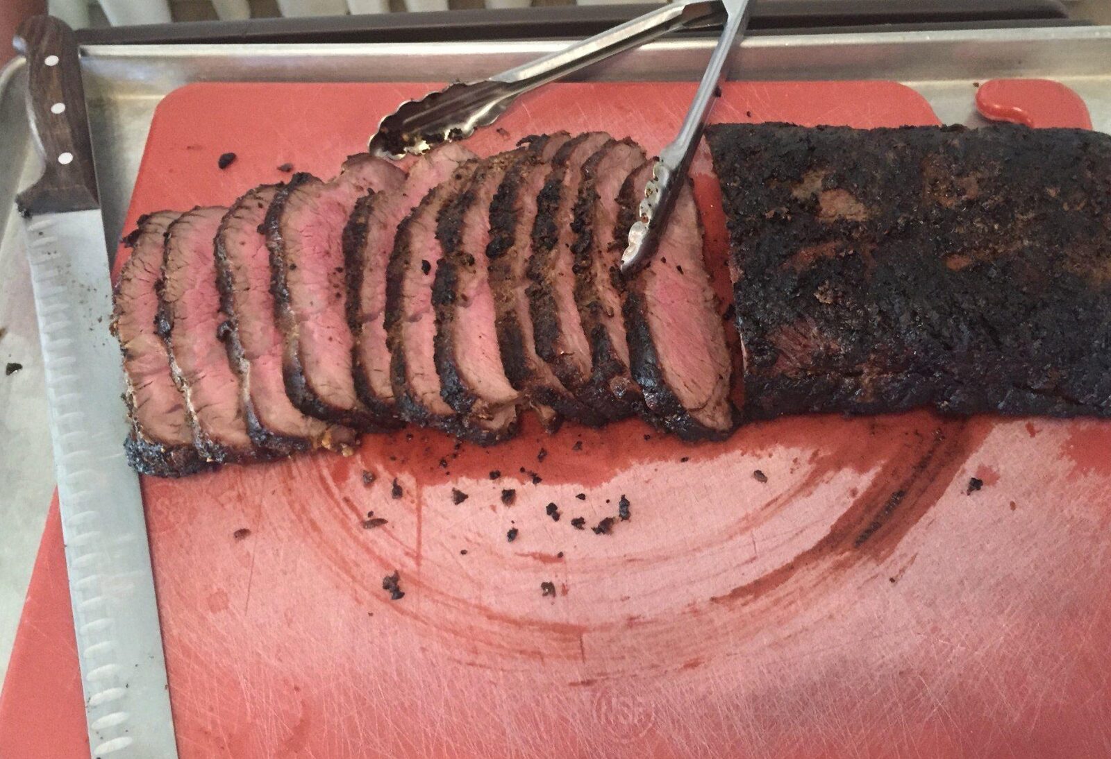 Sliced grilled garlic tri-tip on the cutting board